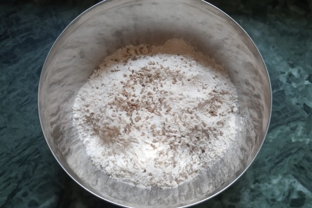 Flour carom seeds and salt in a bowl