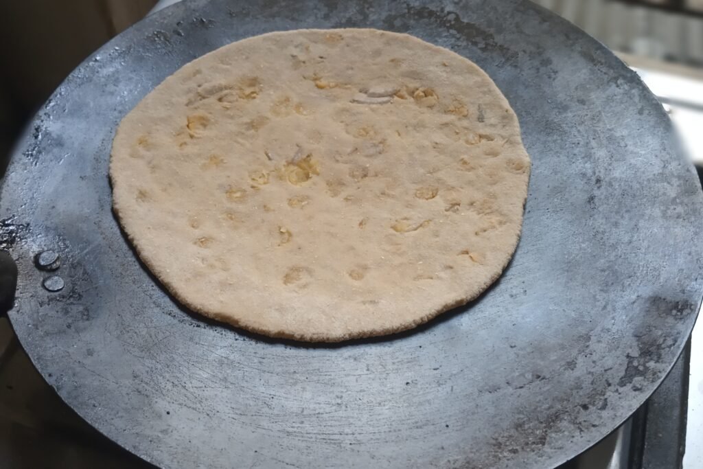 Adding dal chapati on tawa